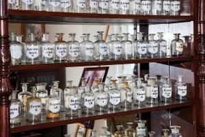 Old glass medicine bottles on the shelf.